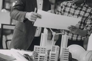 Construction and structure concept of Engineer or architect meeting for project working with partner and engineering tools on model building and blueprint in working site, contract for both companies. photo