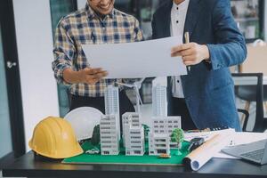 Construction and structure concept of Engineer or architect meeting for project working with partner and engineering tools on model building and blueprint in working site, contract for both companies. photo