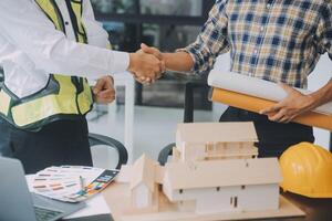 Construction and structure concept of Engineer or architect meeting for project working with partner and engineering tools on model building and blueprint in working site, contract for both companies. photo