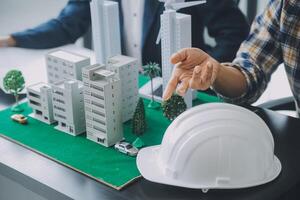 Construction and structure concept of Engineer or architect meeting for project working with partner and engineering tools on model building and blueprint in working site, contract for both companies. photo