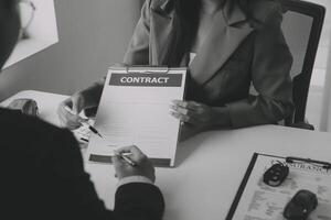 Closeup asian male people car salesman or sales manager offers to sell a car and explains and reads the terms of signing a car contract and insurance. photo