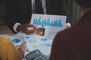 Financial analysts analyze business financial reports on a digital tablet planning investment project during a discussion at a meeting of corporate showing the results of their successful teamwork. photo