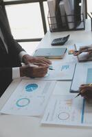 Financial analysts analyze business financial reports on a digital tablet planning investment project during a discussion at a meeting of corporate showing the results of their successful teamwork. photo
