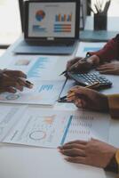 Financial analysts analyze business financial reports on a digital tablet planning investment project during a discussion at a meeting of corporate showing the results of their successful teamwork. photo