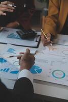 Financial analysts analyze business financial reports on a digital tablet planning investment project during a discussion at a meeting of corporate showing the results of their successful teamwork. photo