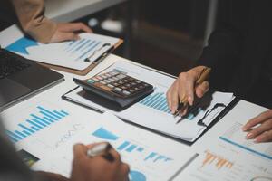 Financial analysts analyze business financial reports on a digital tablet planning investment project during a discussion at a meeting of corporate showing the results of their successful teamwork. photo