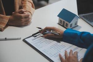 Real estate agent and customer signing contract to buy house, insurance or loan real estate.rent a house,get insurance or loan real estate or property. photo