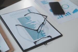 Financial analysts analyze business financial reports on a digital tablet planning investment project during a discussion at a meeting of corporate showing the results of their successful teamwork. photo