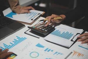 Financial analysts analyze business financial reports on a digital tablet planning investment project during a discussion at a meeting of corporate showing the results of their successful teamwork. photo