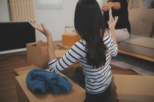 Two Asian blogger showing clothes in front of the camera to recording vlog video live streaming at her shop. Online Shopping Cart notion. on sofa at home photo