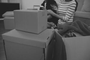 Two Asian blogger showing clothes in front of the camera to recording vlog video live streaming at her shop. Online Shopping Cart notion. on sofa at home photo