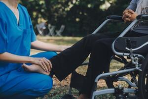 young asian physical therapist working with senior woman on walking with a walker photo