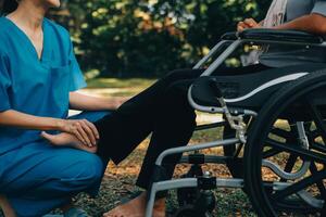 young asian physical therapist working with senior woman on walking with a walker photo