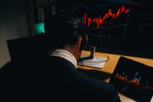 Thoughtful focused successful caucasian male stock investor, broker, financial adviser, sits at work desk, looks at computer, pensively analyze risks and prospects, rise or fall of cryptocurrency coin photo