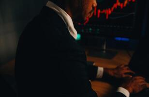 Thoughtful focused successful caucasian male stock investor, broker, financial adviser, sits at work desk, looks at computer, pensively analyze risks and prospects, rise or fall of cryptocurrency coin photo