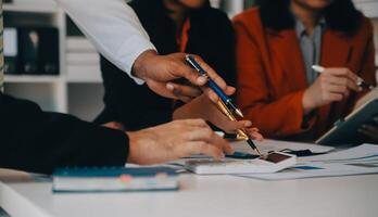 negocio equipo trabajando con nuevo puesta en marcha proyecto plan y discusión información para financiero estrategia con ordenador portátil y digital tableta en un moderno negocio salón. foto