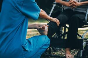 young asian physical therapist working with senior woman on walking with a walker photo