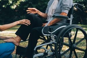 young asian physical therapist working with senior woman on walking with a walker photo