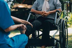 young asian physical therapist working with senior woman on walking with a walker photo