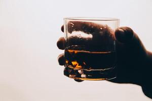 Whiskey splashing out of glass, isolated on white background photo