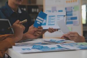 Close up ux developer and ui designer use augmented reality brainstorming about mobile app interface wireframe design on desk at modern office.Creative digital development agency photo