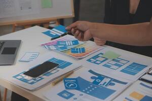 Close up ux developer and ui designer use augmented reality brainstorming about mobile app interface wireframe design on desk at modern office.Creative digital development agency photo