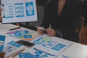 Close up ux developer and ui designer use augmented reality brainstorming about mobile app interface wireframe design on desk at modern office.Creative digital development agency photo