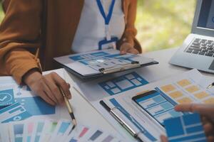 Close up ux developer and ui designer use augmented reality brainstorming about mobile app interface wireframe design on desk at modern office.Creative digital development agency photo
