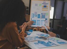 Close up ux developer and ui designer use augmented reality brainstorming about mobile app interface wireframe design on desk at modern office.Creative digital development agency photo