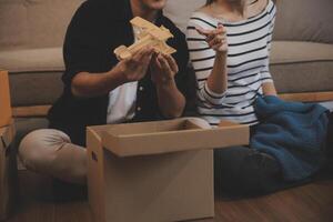 Two Asian blogger showing clothes in front of the camera to recording vlog video live streaming at her shop. Online Shopping Cart notion. on sofa at home photo