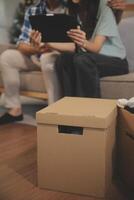 Two Asian blogger showing clothes in front of the camera to recording vlog video live streaming at her shop. Online Shopping Cart notion. on sofa at home photo