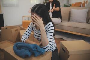 Two Asian blogger showing clothes in front of the camera to recording vlog video live streaming at her shop. Online Shopping Cart notion. on sofa at home photo