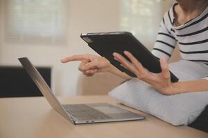 Young attractive asian woman resting using browsing tablet computer on sofa at home, happy girl sitting on couch relax reading digital gadget with excited, communication and lifestyle concept. photo