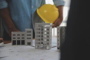 Construction and structure concept of Engineer or architect meeting for project working with partner and engineering tools on model building and blueprint in working site, contract for both companies. photo