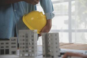 Construction and structure concept of Engineer or architect meeting for project working with partner and engineering tools on model building and blueprint in working site, contract for both companies. photo
