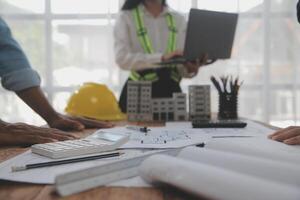 Construction and structure concept of Engineer or architect meeting for project working with partner and engineering tools on model building and blueprint in working site, contract for both companies. photo