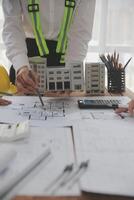 concepto de construcción y estructura de reunión de ingenieros o arquitectos para el proyecto que trabaja con socios y herramientas de ingeniería en la construcción de modelos y planos en el lugar de trabajo, contrato para ambas empresas. foto