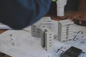 concepto de construcción y estructura de reunión de ingenieros o arquitectos para el proyecto que trabaja con socios y herramientas de ingeniería en la construcción de modelos y planos en el lugar de trabajo, contrato para ambas empresas. foto