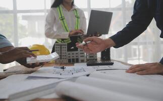 Construction and structure concept of Engineer or architect meeting for project working with partner and engineering tools on model building and blueprint in working site, contract for both companies. photo