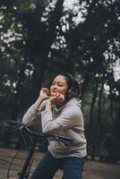 Happy Asian young woman walk and ride bicycle in park, street city her smiling using bike of transportation, ECO friendly, People lifestyle concept. photo