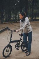 Happy Asian young woman walk and ride bicycle in park, street city her smiling using bike of transportation, ECO friendly, People lifestyle concept. photo