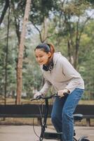 Happy Asian young woman walk and ride bicycle in park, street city her smiling using bike of transportation, ECO friendly, People lifestyle concept. photo