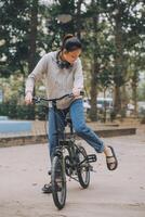 Happy Asian young woman walk and ride bicycle in park, street city her smiling using bike of transportation, ECO friendly, People lifestyle concept. photo