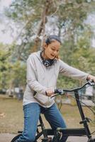 Happy Asian young woman walk and ride bicycle in park, street city her smiling using bike of transportation, ECO friendly, People lifestyle concept. photo