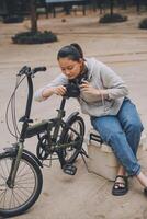 Happy Asian young woman walk and ride bicycle in park, street city her smiling using bike of transportation, ECO friendly, People lifestyle concept. photo