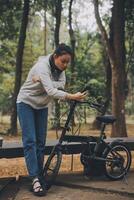 Happy Asian young woman walk and ride bicycle in park, street city her smiling using bike of transportation, ECO friendly, People lifestyle concept. photo