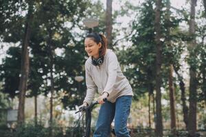 Happy Asian young woman walk and ride bicycle in park, street city her smiling using bike of transportation, ECO friendly, People lifestyle concept. photo