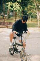 hermoso contento joven hombre con bicicleta en un ciudad calle, activo estilo de vida, personas concepto foto