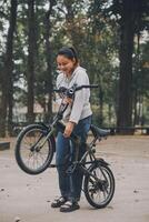 Happy Asian young woman walk and ride bicycle in park, street city her smiling using bike of transportation, ECO friendly, People lifestyle concept. photo