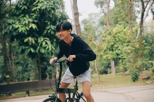 hermoso contento joven hombre con bicicleta en un ciudad calle, activo estilo de vida, personas concepto foto